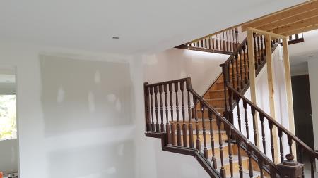 a home renovation including drywall transformations around existing wood staircase MD-DRYWALL Incorporated Airdrie (403)880-4767