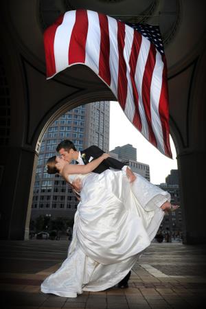 bride and groom kissing under the america flag at the rowes wharf in boston - www.adrianobatti.com Adriano Batti Photography Medford (781)306-1110