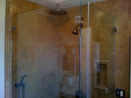 Travertine shower tile, oil rubbed bronze fixtures, frameless door. Performance Construction & Remodeling Inc. Chino Hills (714)655-6427