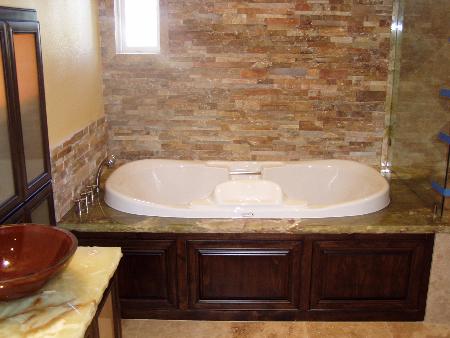 Spa tub with ledger stone walls, alder cabinetry, and chisled edge onyx counter tops. Performance Construction & Remodeling Inc. Chino Hills (714)655-6427